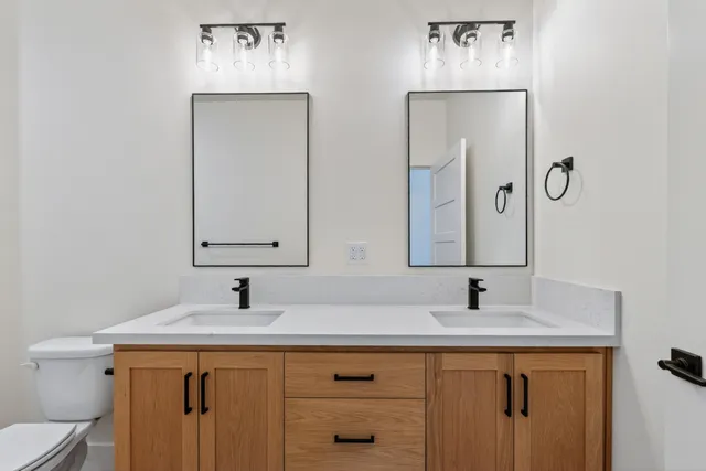 an empty room with wooden floor cabinet and windows
