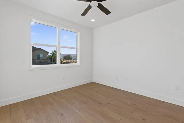 an empty room with a window and a ceiling fan