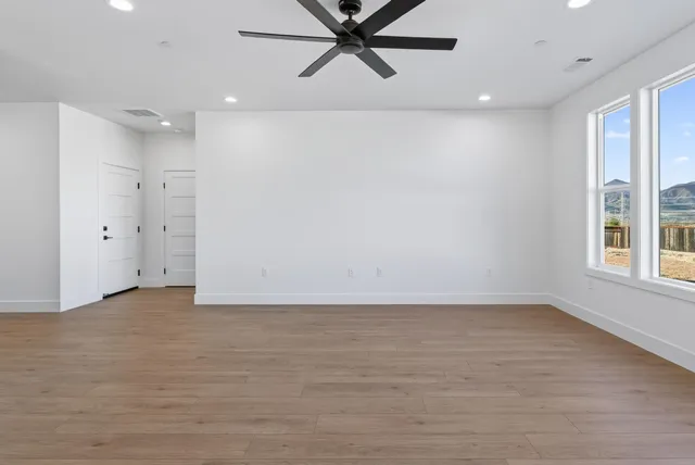 an empty room with window and a ceiling fan