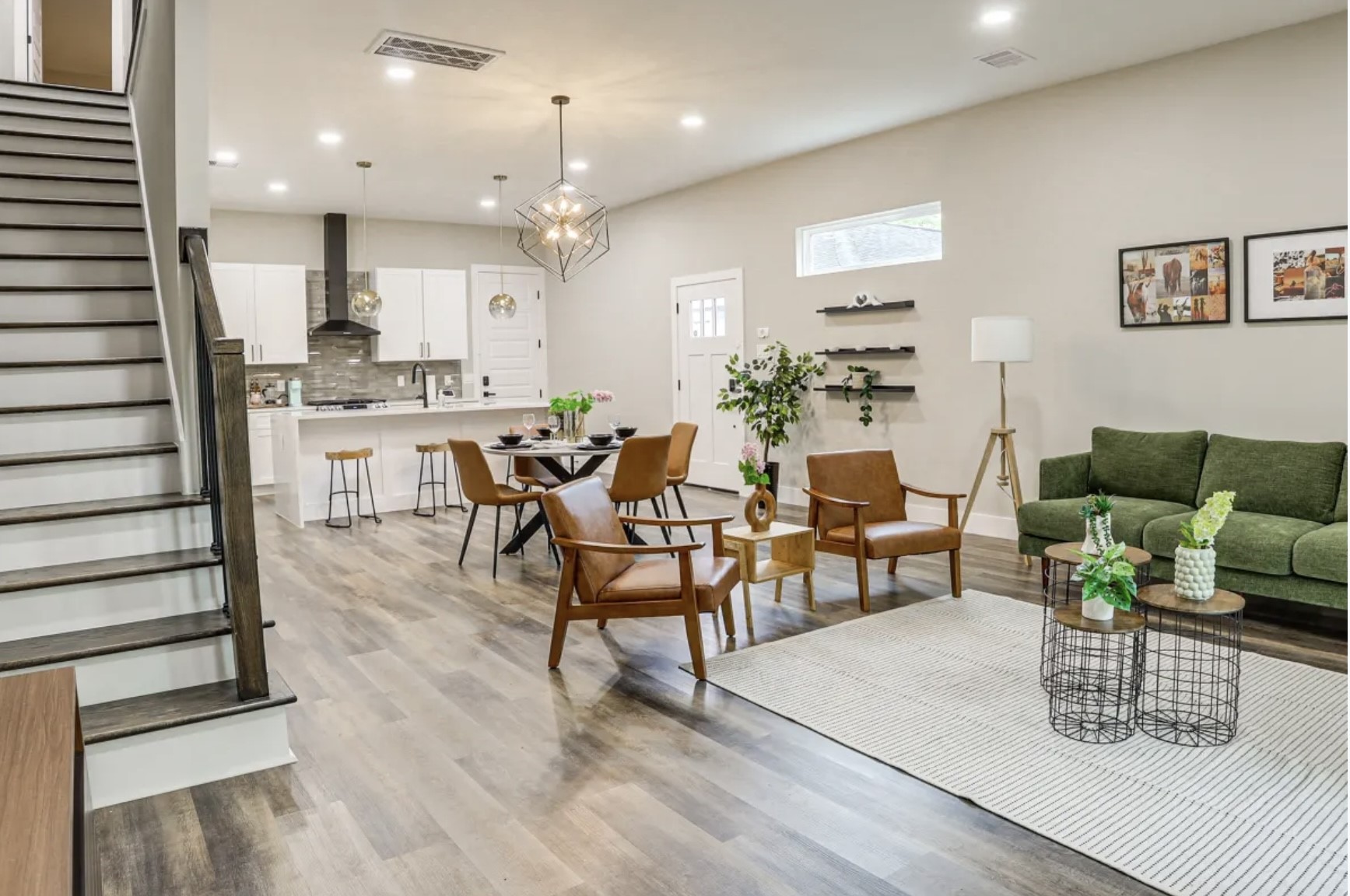 3727 Dreyfus Street Houston, TX 77021 - Photo 5 of 17 This open-concept living space features modern decor with a stylish kitchen, dining, and living area. It has sleek wood flooring, a contemporary staircase, and ample natural light.