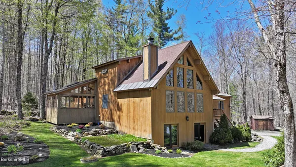 a front view of a house with a yard and an tree