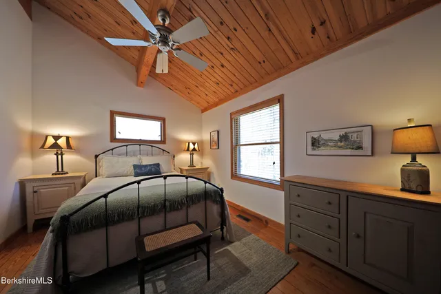 a bedroom with a bed a lamp on dresser and a window