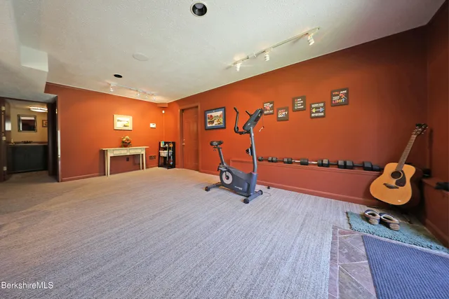a room with gym equipment and wooden floor