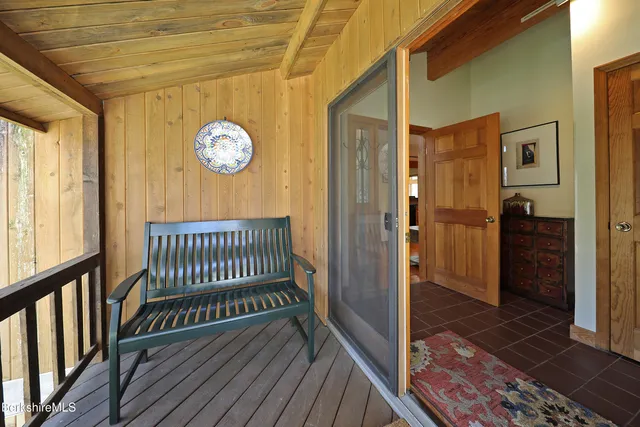 a view of a hallway with wooden floor and a bathroom