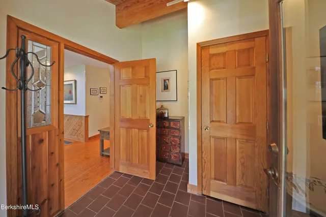 a view of a hallway with wooden floor and closet area