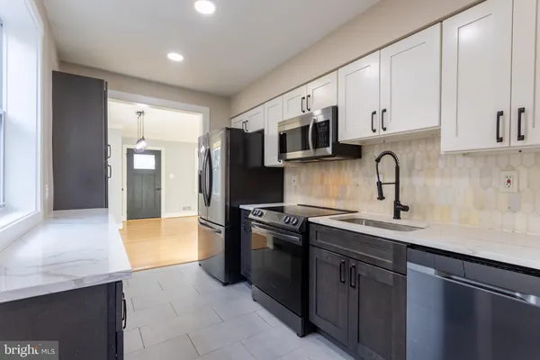 a kitchen with stainless steel appliances a sink stove and refrigerator