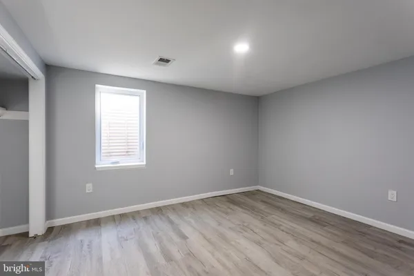 an empty room with wooden floor and window