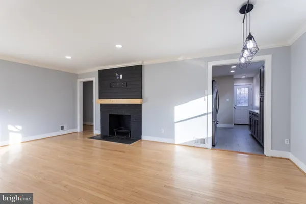a view of a livingroom with a fireplace a chandelier and wooden floor