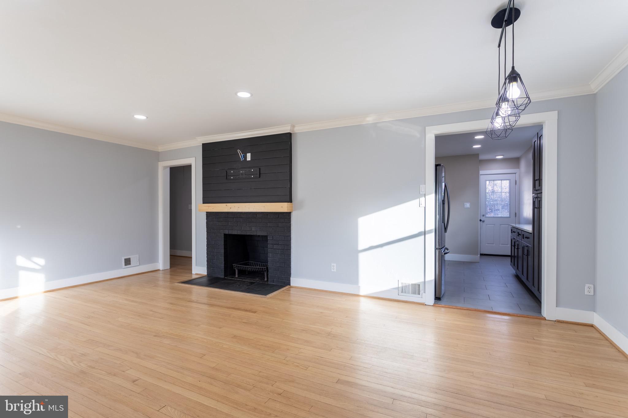 1809 Florin Street Silver Spring, MD 20902 - Photo 10 of 41 a view of a livingroom with a fireplace a chandelier and wooden floor