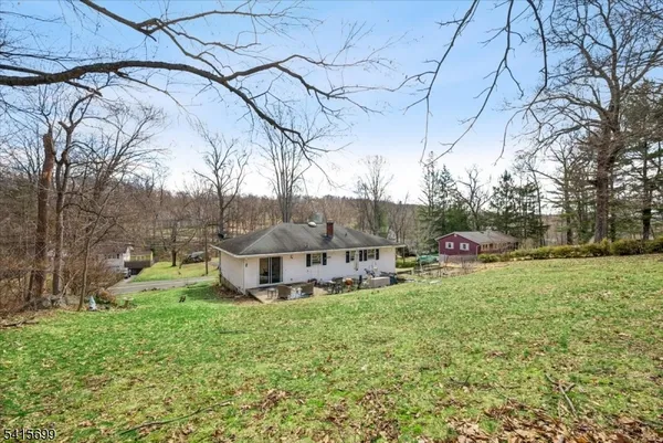 a view of backyard with a barn and a large tree