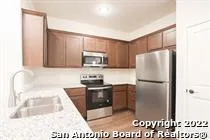 a kitchen with stainless steel appliances granite countertop a refrigerator a stove a sink and a microwave