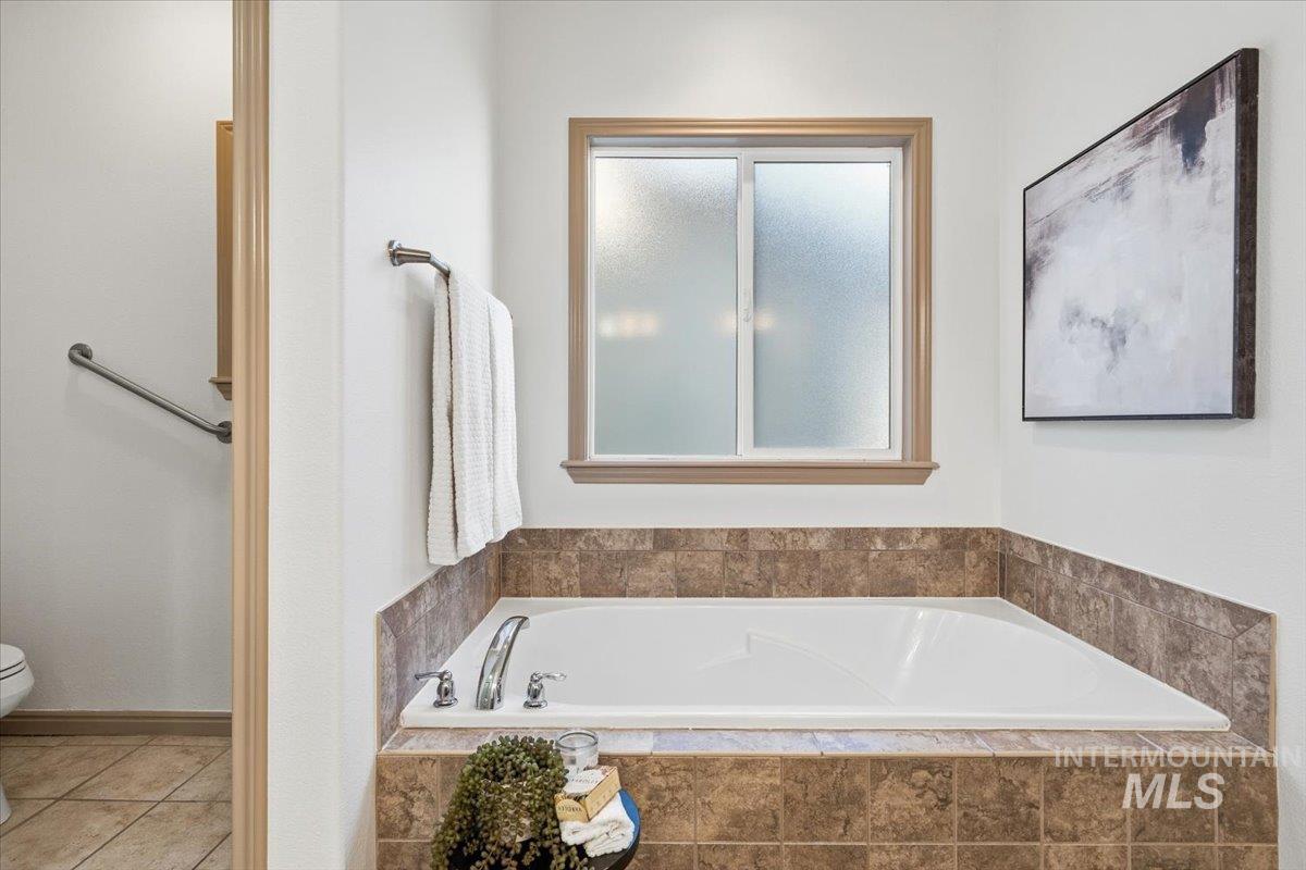 1183 North Buffalo Way Middleton, ID 83644 - Photo 21 of 47 Built-in soaking tub with tile surround, brushed nickel fixtures, and a privacy window