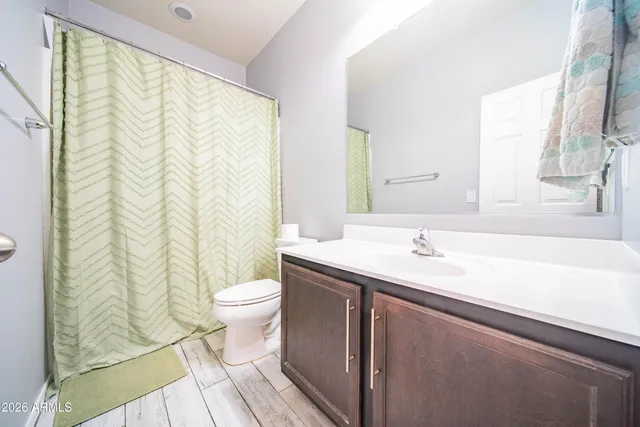 a bathroom with a granite countertop sink a toilet and a mirror