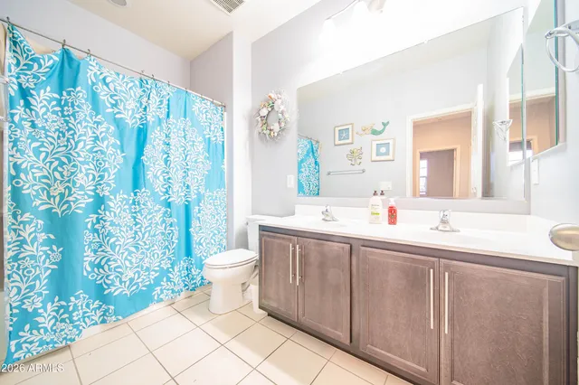 a bathroom with a double vanity sink toilet and shower