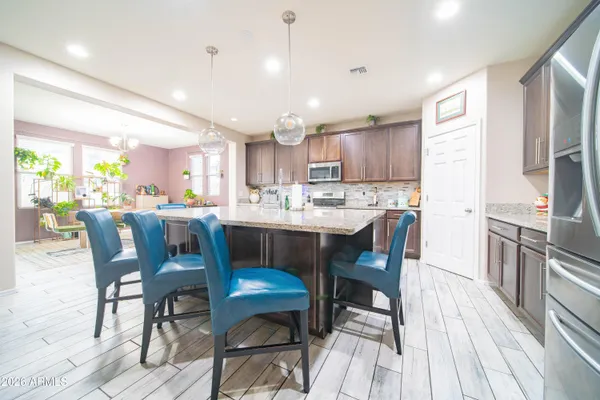 a kitchen with a dining table chairs and refrigerator