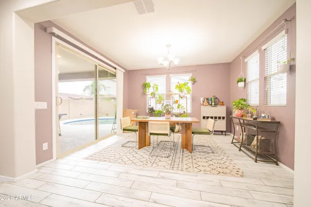 a dining room with wooden floor and large window