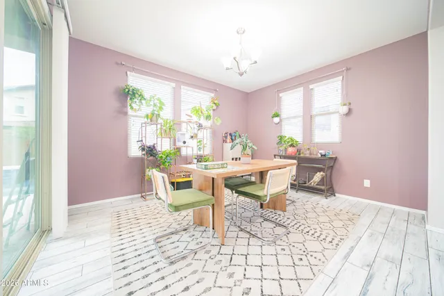 a dining room with chandelier fan and wooden floor