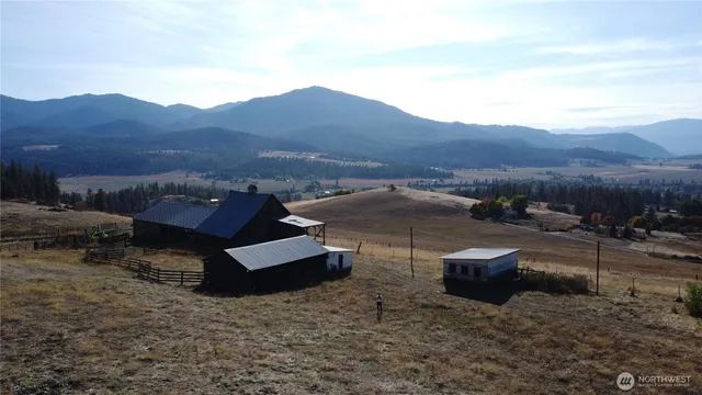 a view of a dry yard with wooden fence