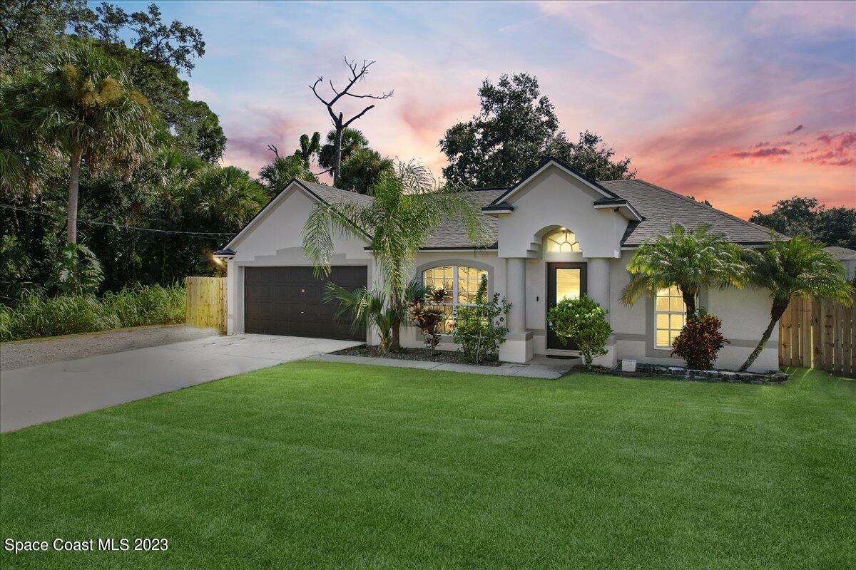 a front view of a house with a garden and yard