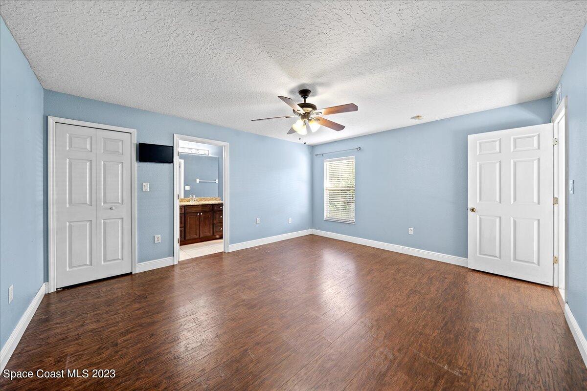 6949 Boston Road Cocoa, FL 32927 - Photo 14 of 33 an empty room with wooden floor ceiling fan and windows