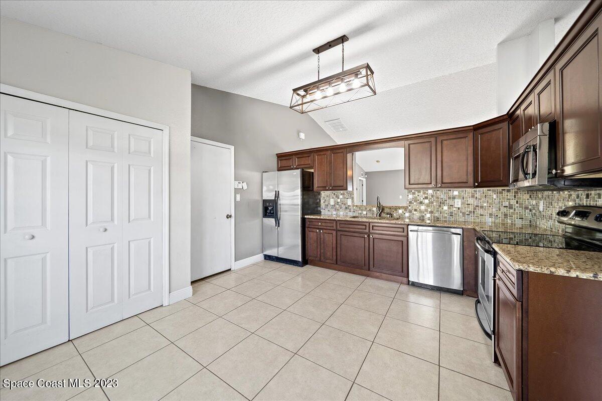 6949 Boston Road Cocoa, FL 32927 - Photo 5 of 33 a kitchen with stainless steel appliances granite countertop a refrigerator and a stove top oven