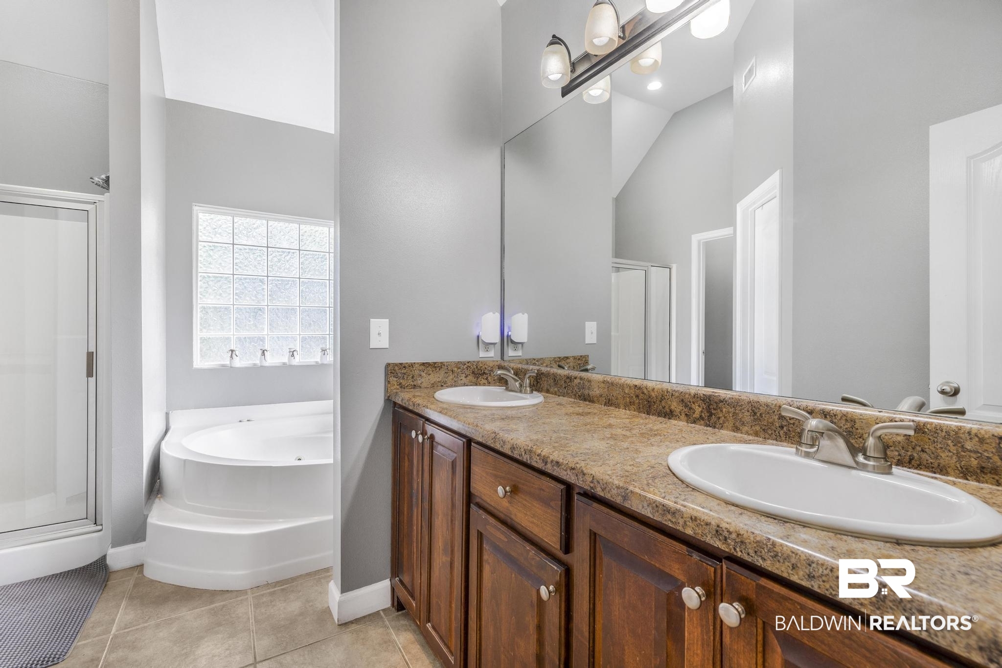 35814 Delvan Lane Bay Minette, AL 36507 - Photo 22 of 53 Double vanity featuring wood cabinetry, integrated sinks, and a stone-finish countertop