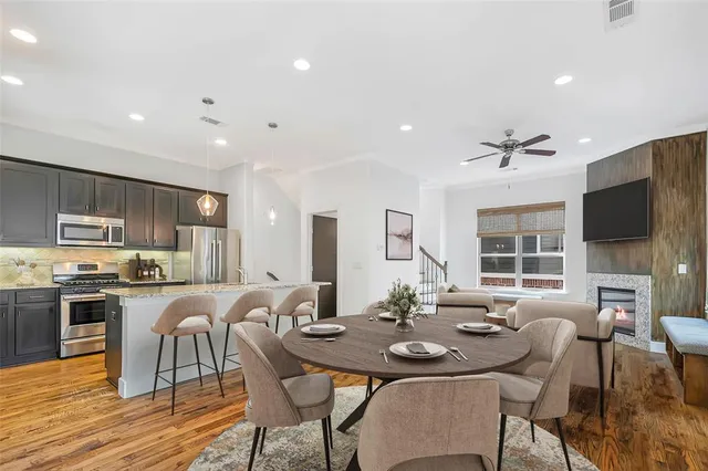 a view of a dining room with furniture a kitchen and chandelier