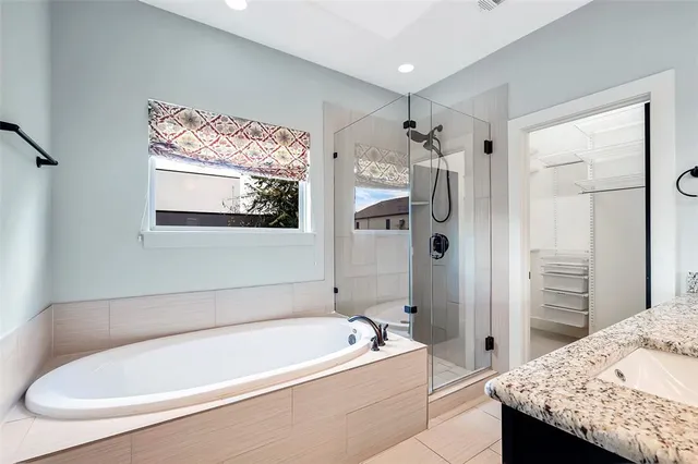 a bathroom with a tub a sink and a shower