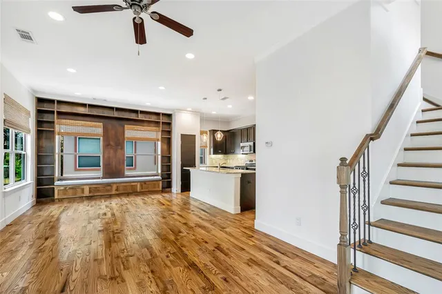 a view of an empty room with a kitchen and a window
