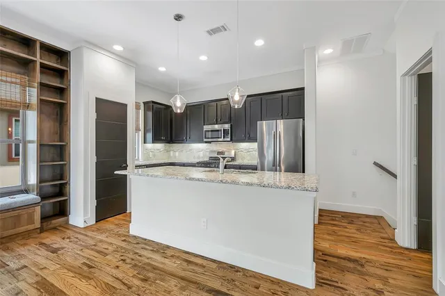a kitchen with stainless steel appliances granite countertop a refrigerator and a sink