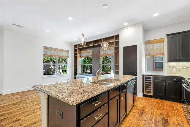 a kitchen with stainless steel appliances granite countertop sink stove and refrigerator