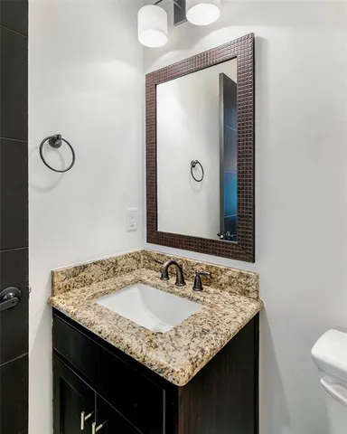 a bathroom with a granite countertop sink and a mirror