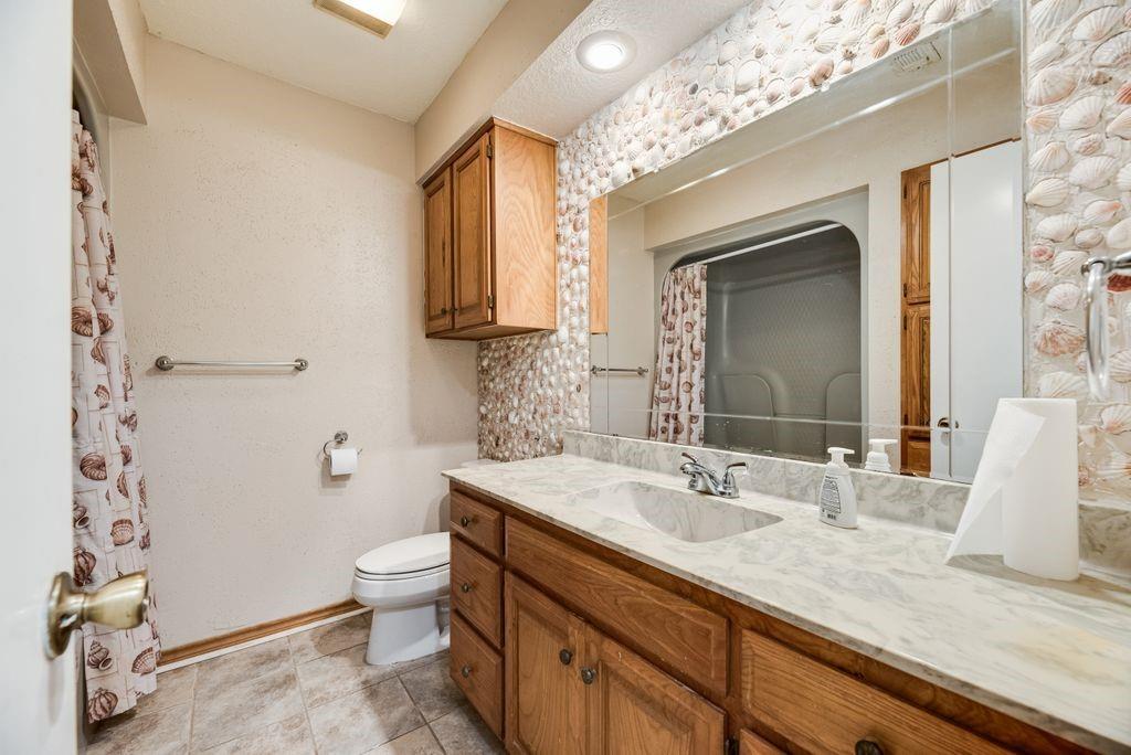 298 Butterfield Road Denison, TX 75021 - Photo 12 of 34 Bathroom vanity featuring a light-colored countertop with an integrated sink and chrome faucet