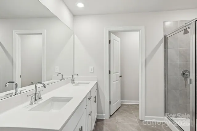 a bathroom with a double vanity sink mirror and shower