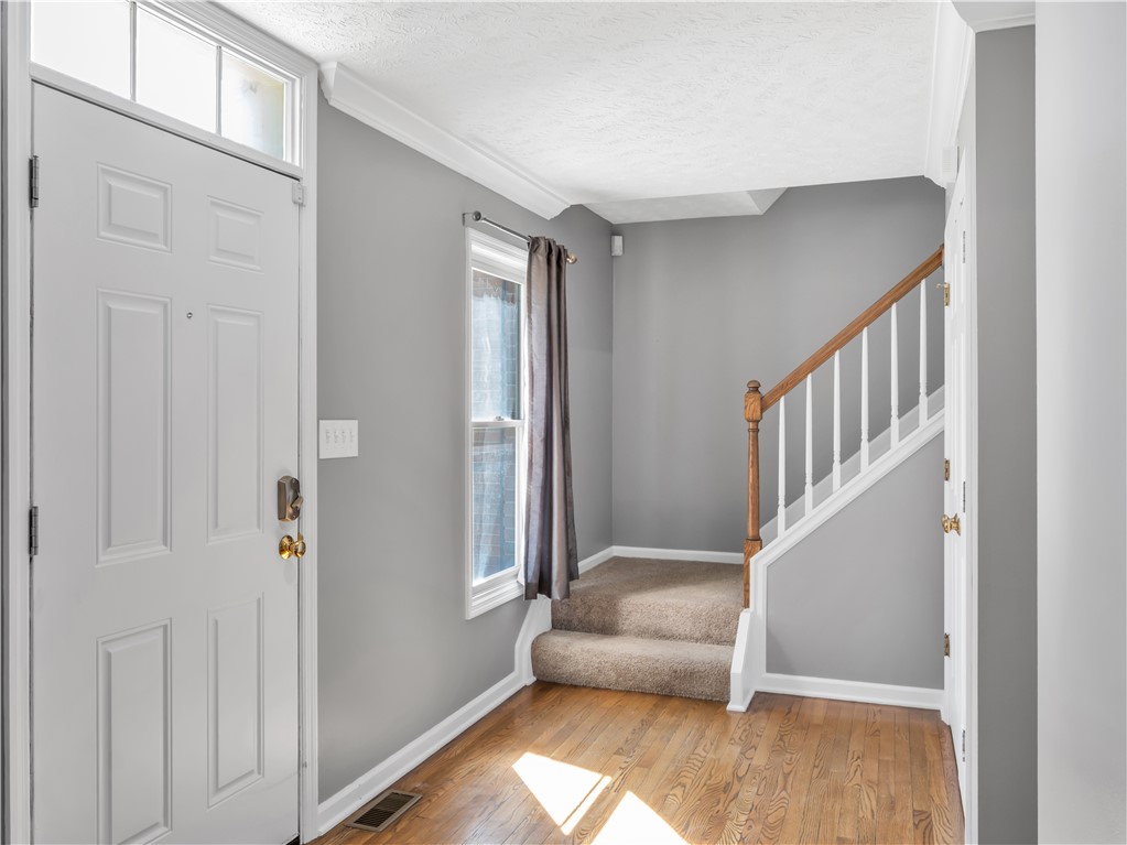 25 Callaway Springboro, OH 45066 - Photo 5 of 51 The inviting entrance features rich hardwood floors, a bright doorway, and an elegant staircase.