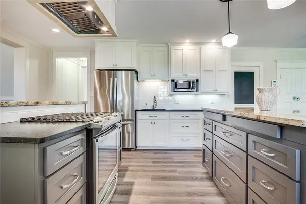 a kitchen with stainless steel appliances granite countertop a stove and a sink