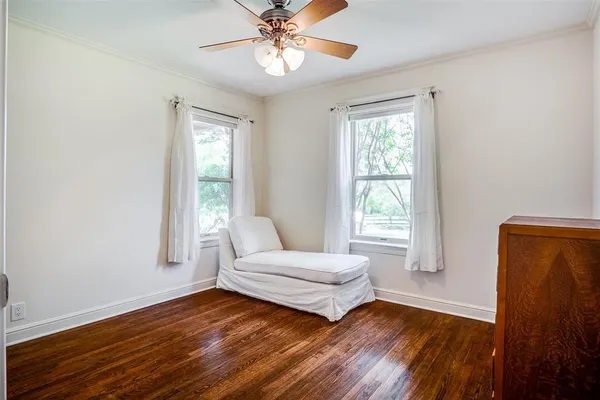 a bedroom with wooden floor and window