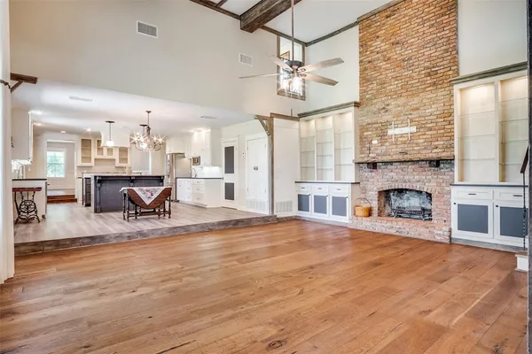 a view of a livingroom with furniture a chandelier and wooden floor