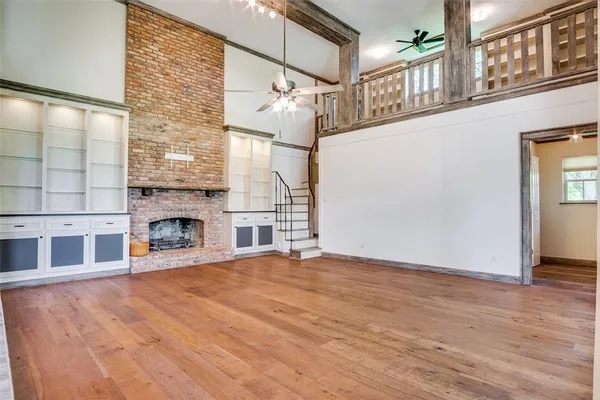 a view of empty room with fireplace and wooden floor