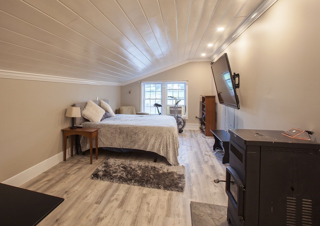 295 Stumpfield Road Hopkinton, NH 03229 - Photo 21 of 36 a bedroom with a bed and wooden floor