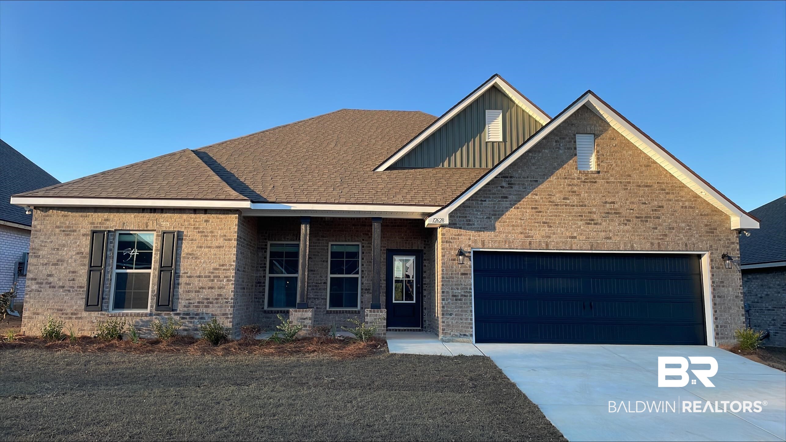 12628 Wagner Avenue Daphne, AL 36527 - Photo 1 of 3 View of front of house with concrete driveway, a porch, brick siding, and an attached garage