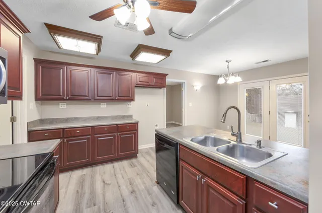 a kitchen with kitchen island granite countertop a sink stainless steel appliances and cabinets