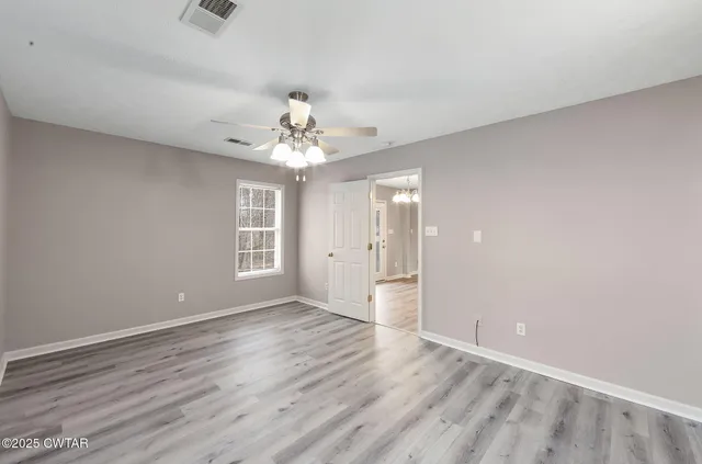 wooden floor in an empty room with a window