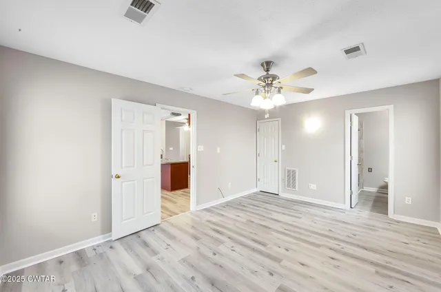 wooden floor in an empty room with a ceiling fan
