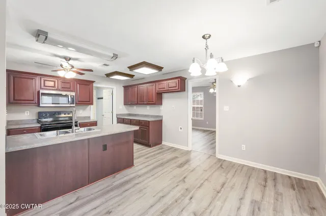 a large kitchen with cabinets wooden floor and stainless steel appliances