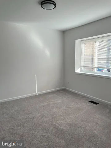 a view of empty room with window and fireplace