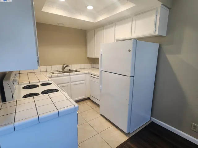 a kitchen with a refrigerator a stove a sink and cabinets