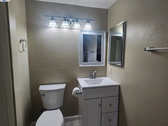a bathroom with a toilet sink and mirror