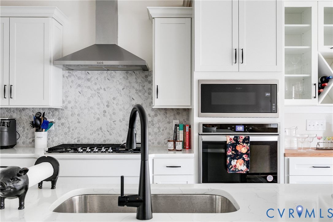 10123 Peach Blossom Road Mechanicsville, VA 23116 - Photo 11 of 49 a kitchen with a stove a microwave and cabinets