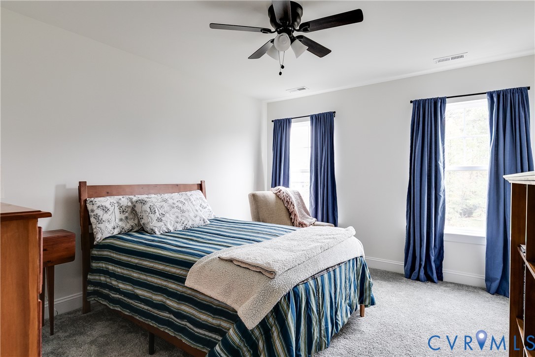 10123 Peach Blossom Road Mechanicsville, VA 23116 - Photo 36 of 49 a bedroom with a bed and a chandelier